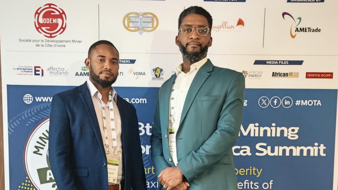 Jean-Phillipe Seya and Franck Alloghe in front of the Mining on Top Africa banner wall.